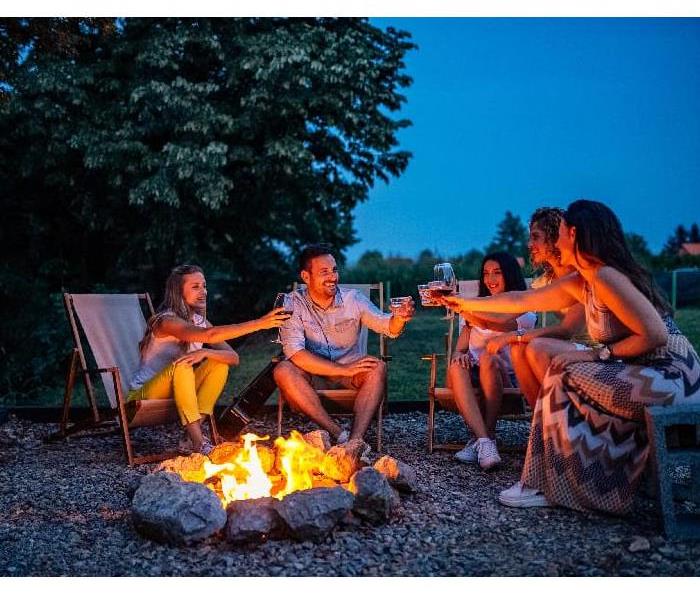 photo of people roasting marshmallows around a fire